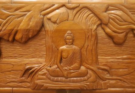 The prince finds enlightenment under the bodhi tree and becomes the Buddha (from painting by Nosu, Japan). Wood carving by Harry Koizumi. Photo by Paride Stortini, used with permission of the Buddhist Temple of Chicago