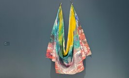 Yellow, teal, red, and blue colorful cloth draped on teal-colored wall