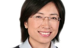 Headshot of a woman with dark hair and glasses.