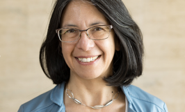 Headshot of a woman with shoulder length dark hair and glasses