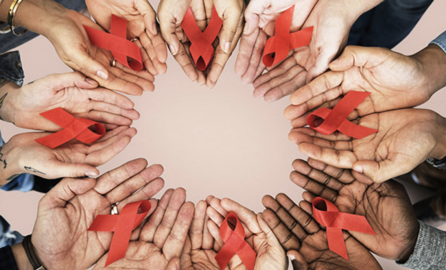 open hands in a circle; each holds a red ribbon