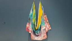 Yellow, teal, red, and blue colorful cloth draped on teal-colored wall